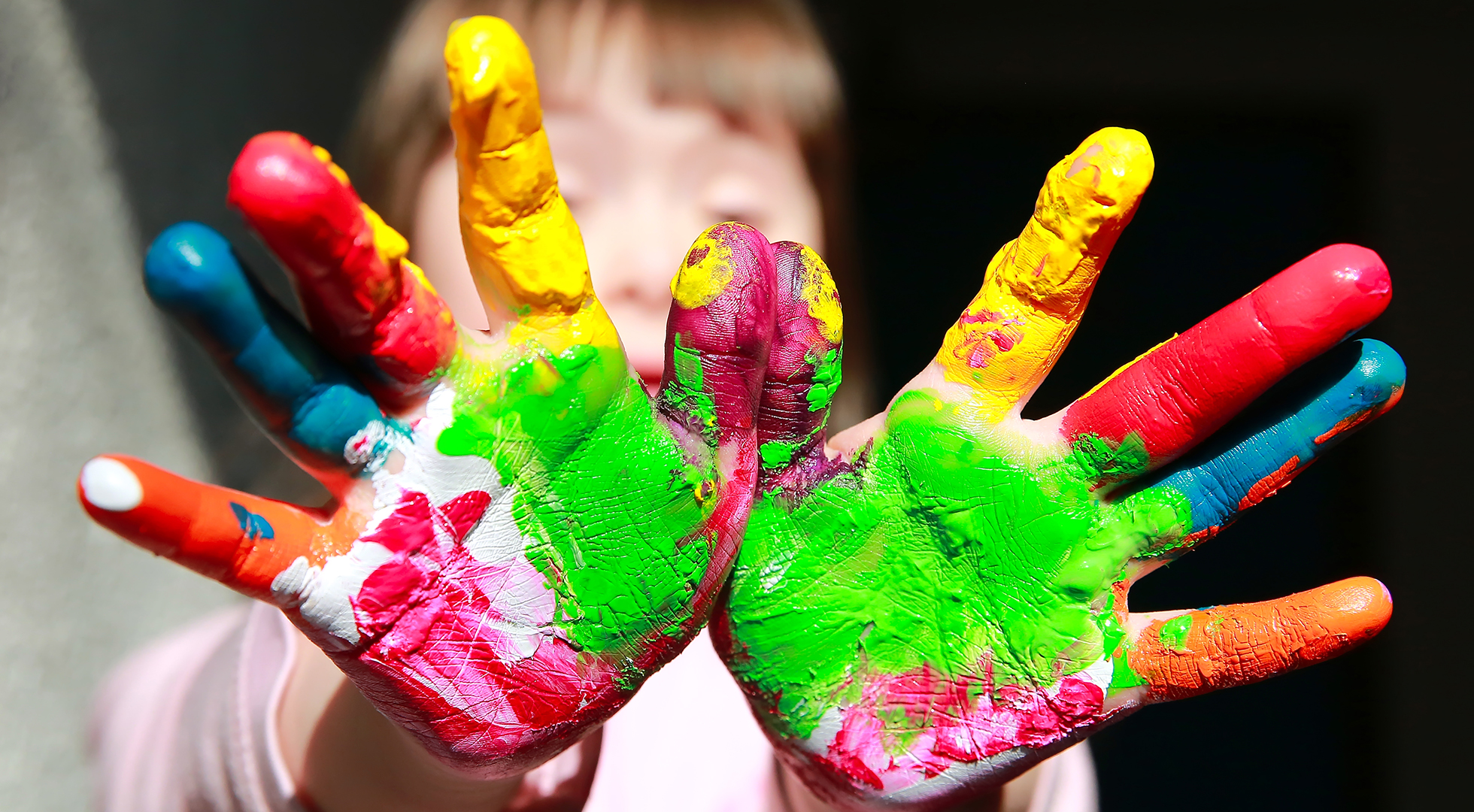 Bambina affetta da Sindrome di Down che gioca con la pittura