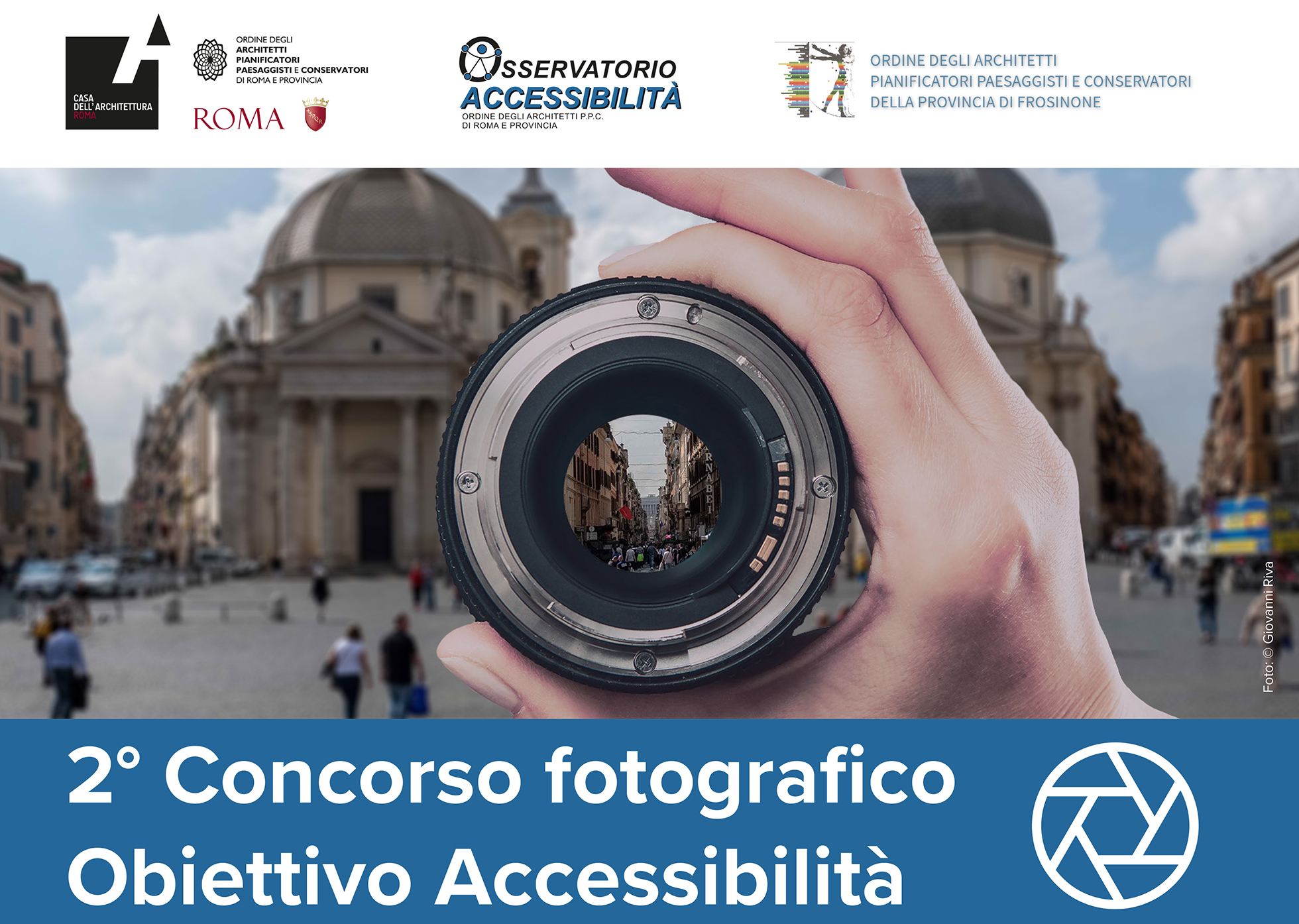 Foto ufficiale del concorso "Obiettivo accessibilità". Una mano che tiene un obiettivo puntato su Via del Corso a Roma
