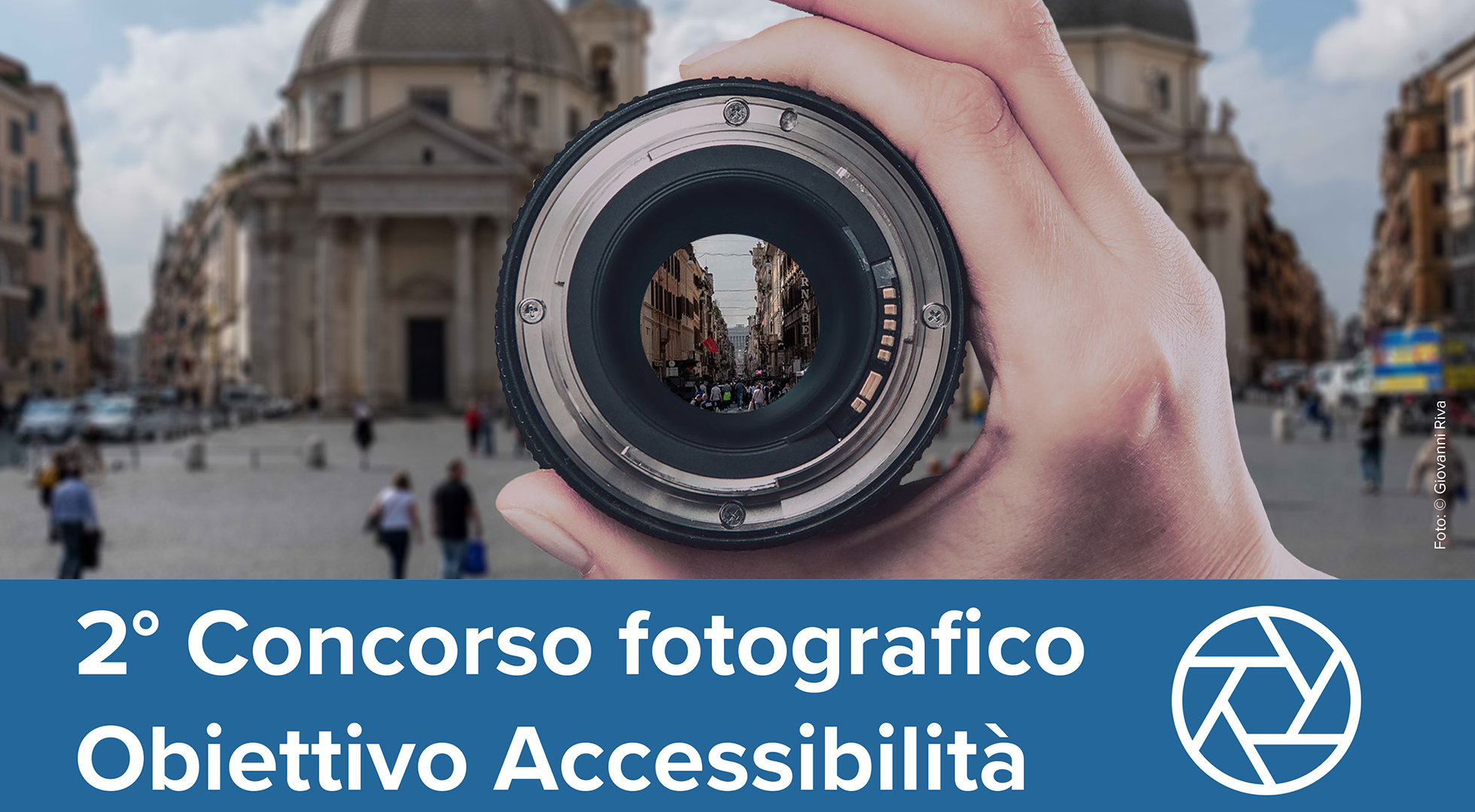 Foto ufficiale del concorso "Obiettivo accessibilità". Una mano che tiene un obiettivo puntato su Via del Corso a Roma